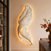 Modern feather wall lamp creating warm ambient lighting in a contemporary living room.