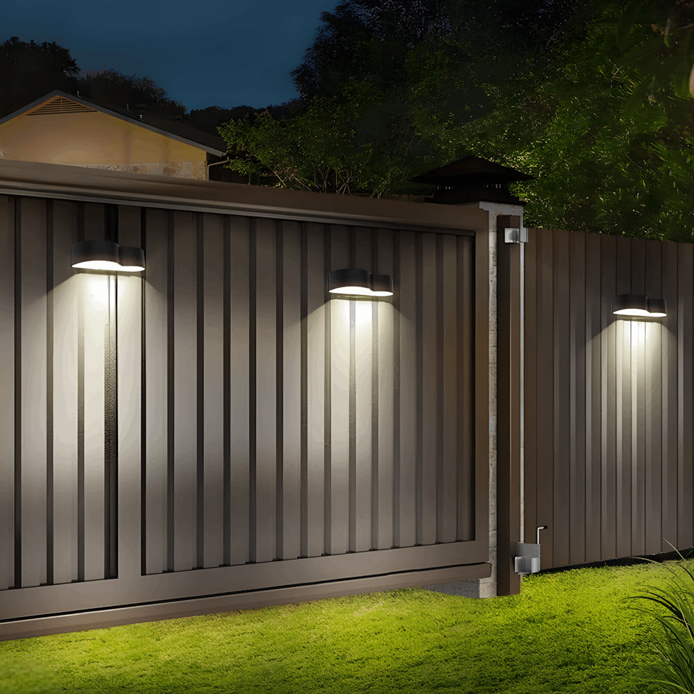 Modern fence illuminated by sleek wall-mounted LED fixtures creating dramatic downward lighting effect