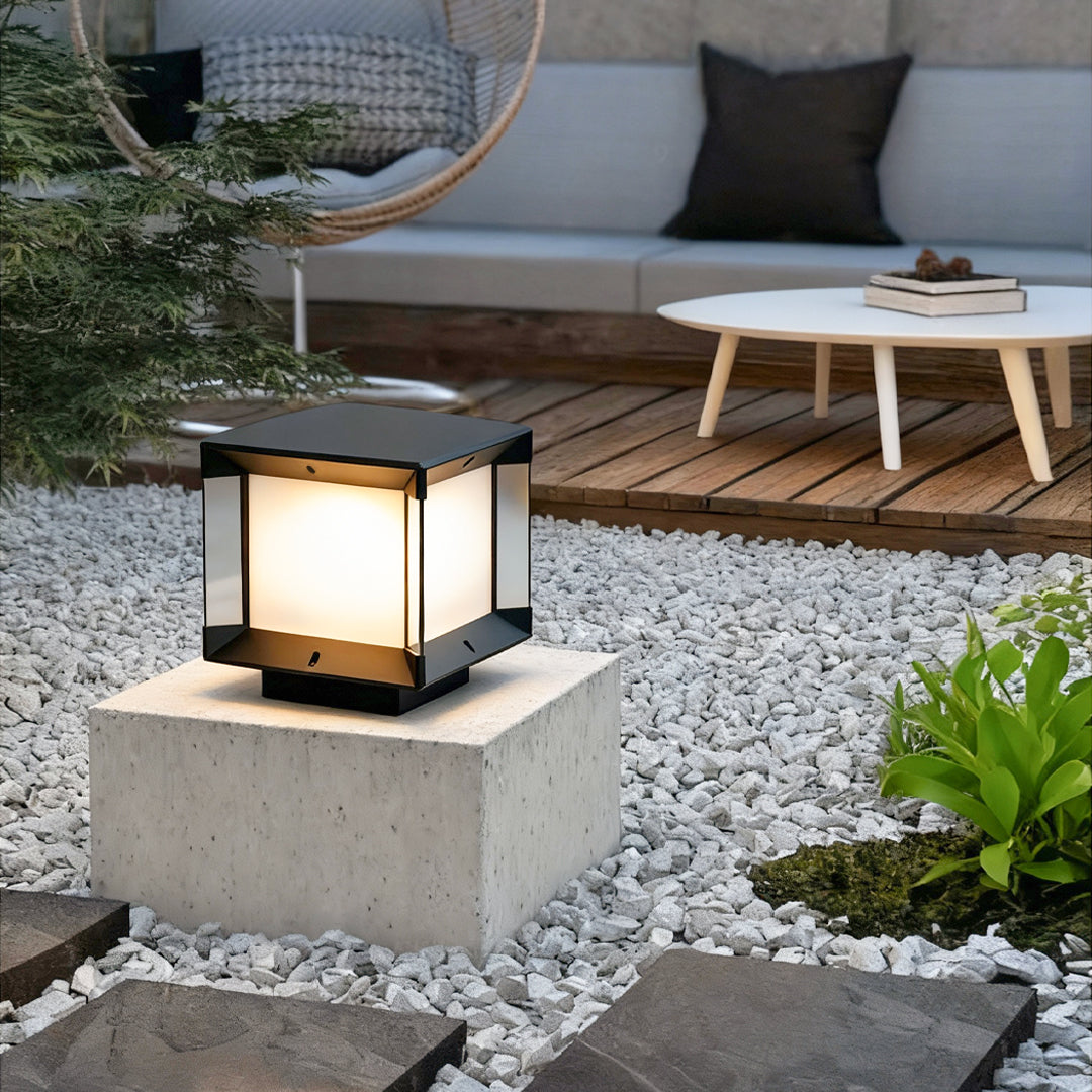 Pillar lights outdoor modern set along a fence with warm night lighting.