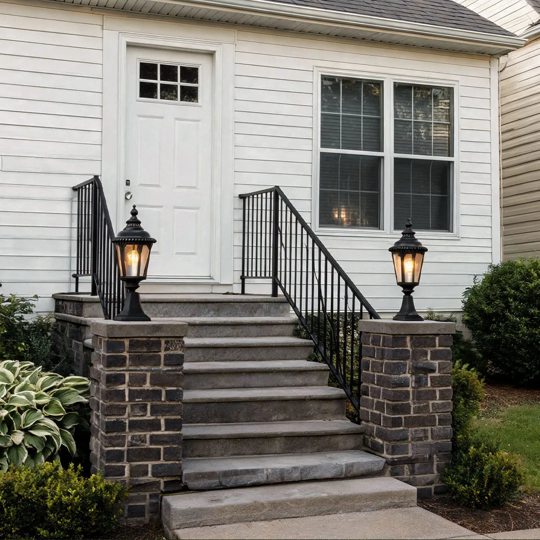 Fence pillar lights installed along brick entry steps, adding warm illumination to the front walkway.