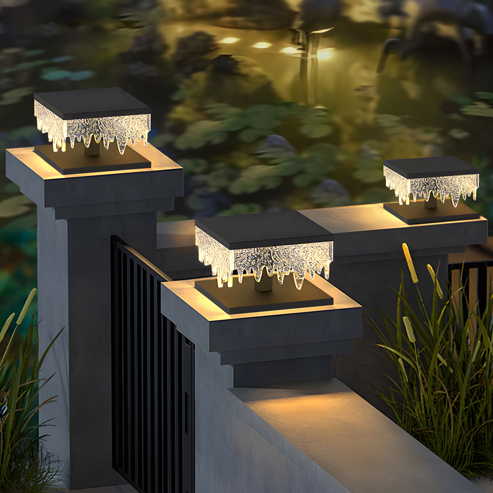 Fence pillar lights casting a gentle glow along a modern driveway.