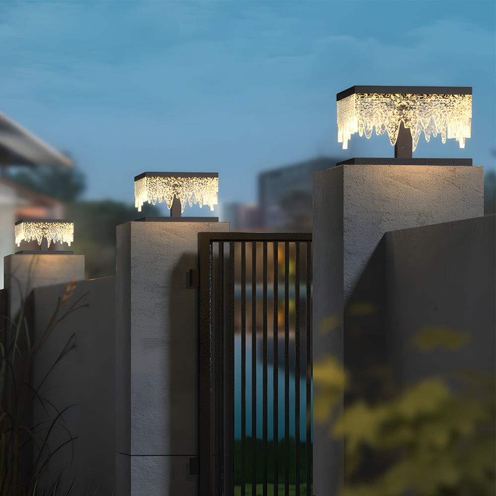 Fence pillar lights illuminating a poolside area with ambient light.