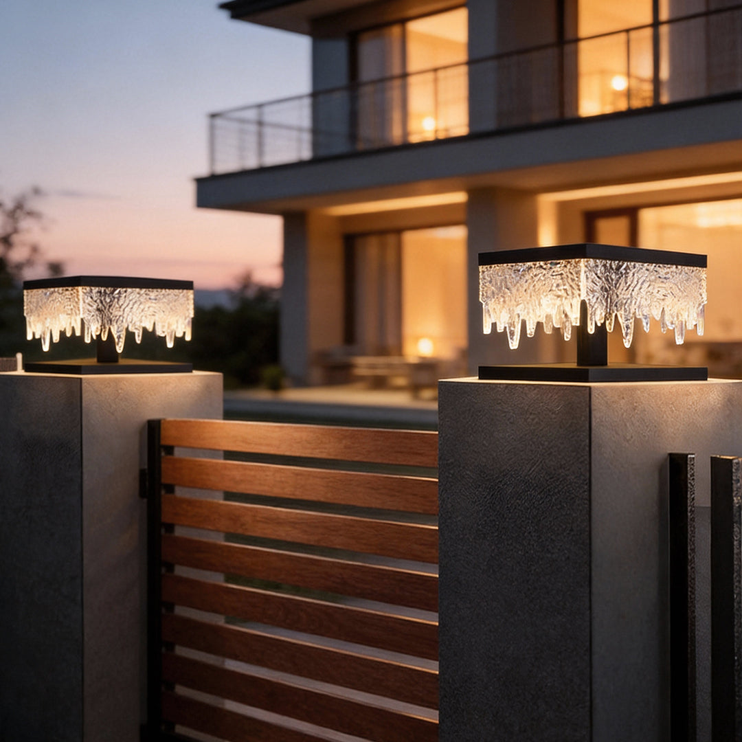 Fence pillar lights providing soft illumination beside a contemporary house entrance.