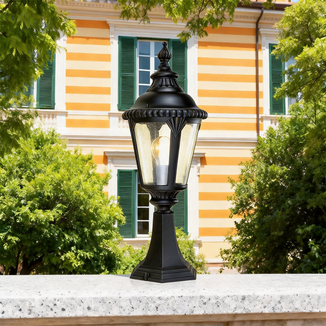 Fence pillar lights styled on a white wall ledge in front of a striped house exterior.