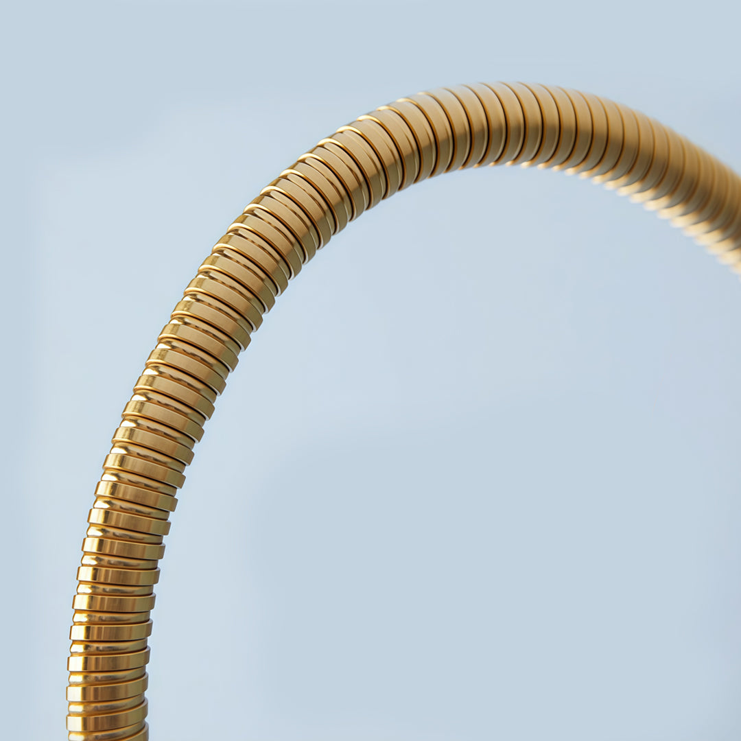 Close-up detail of flexible swing arm wall light in brushed gold finish.