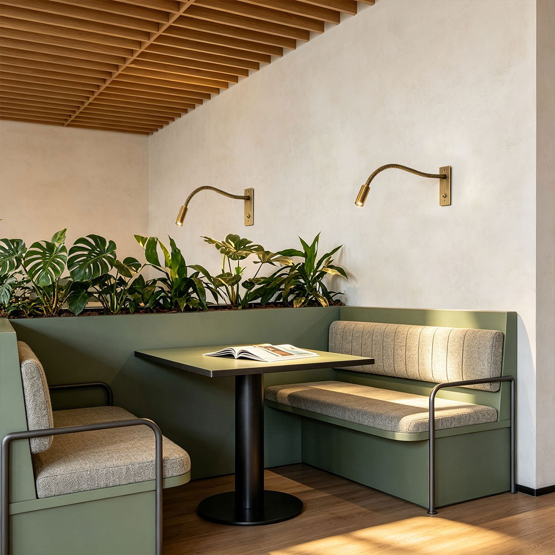 Flexible swing arm wall mount light used in modern café booth lighting design.