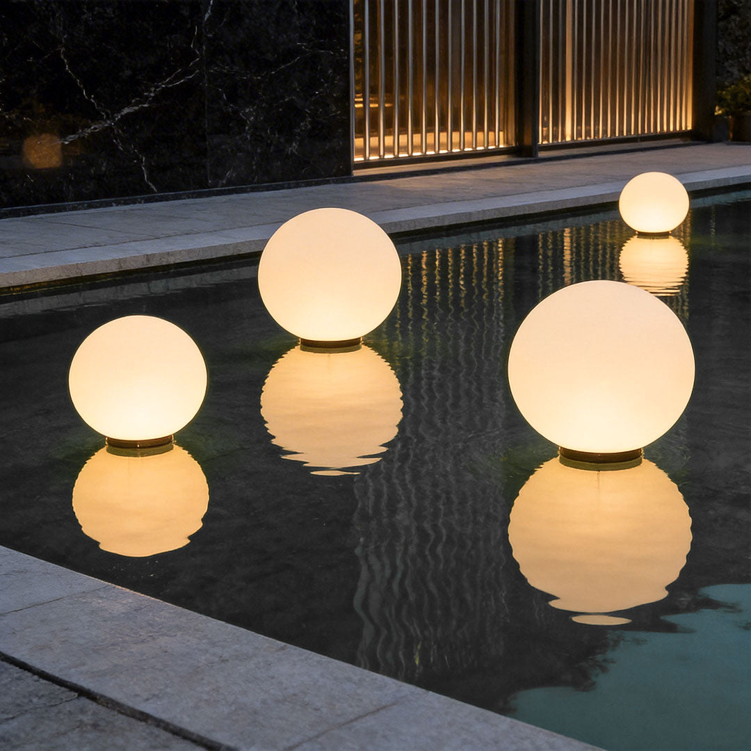 Floating round landscape lighting globes glowing in a dark swimming pool with reflections!!