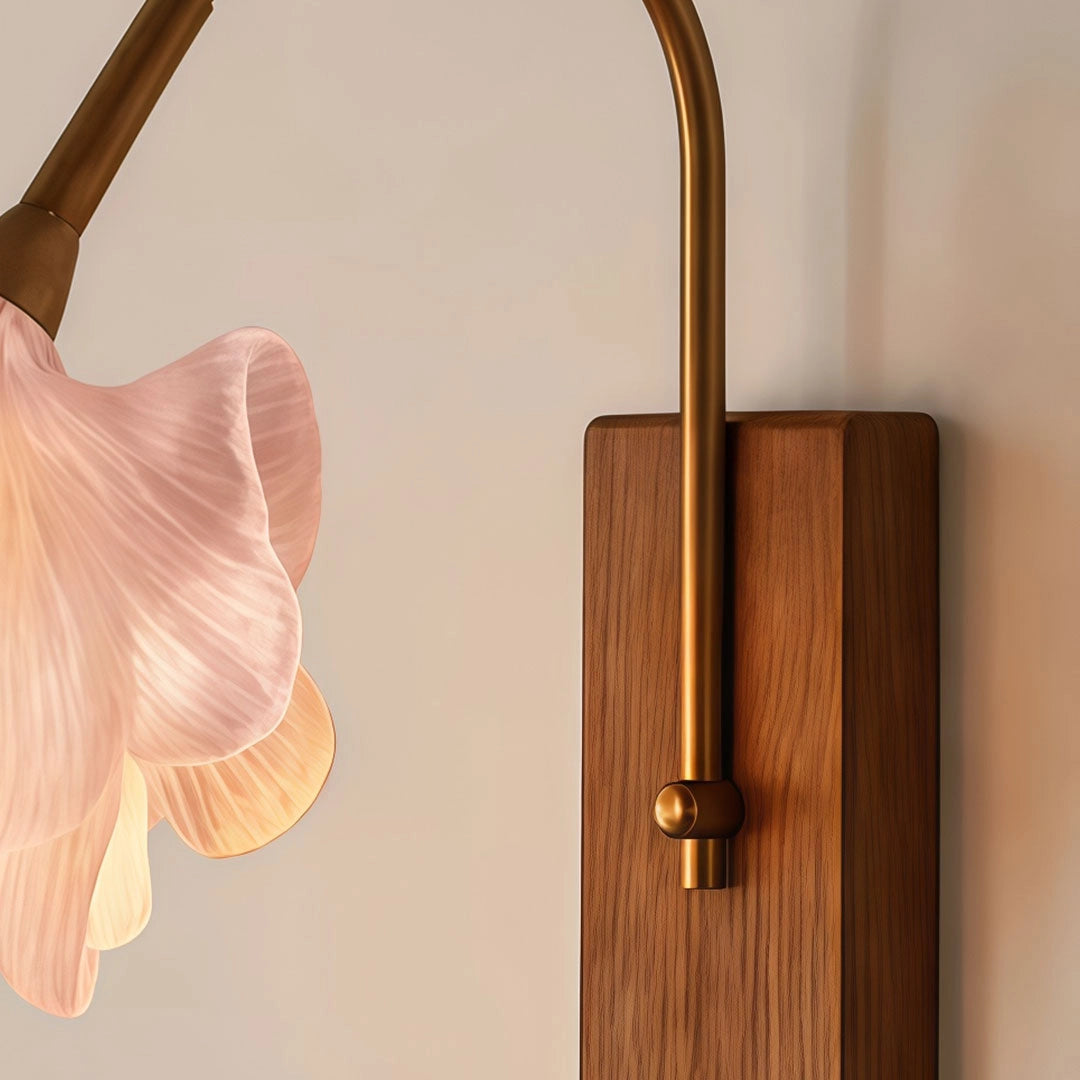 Close-up of a flower wall light showing the curved arm and rectangular backplate detail.