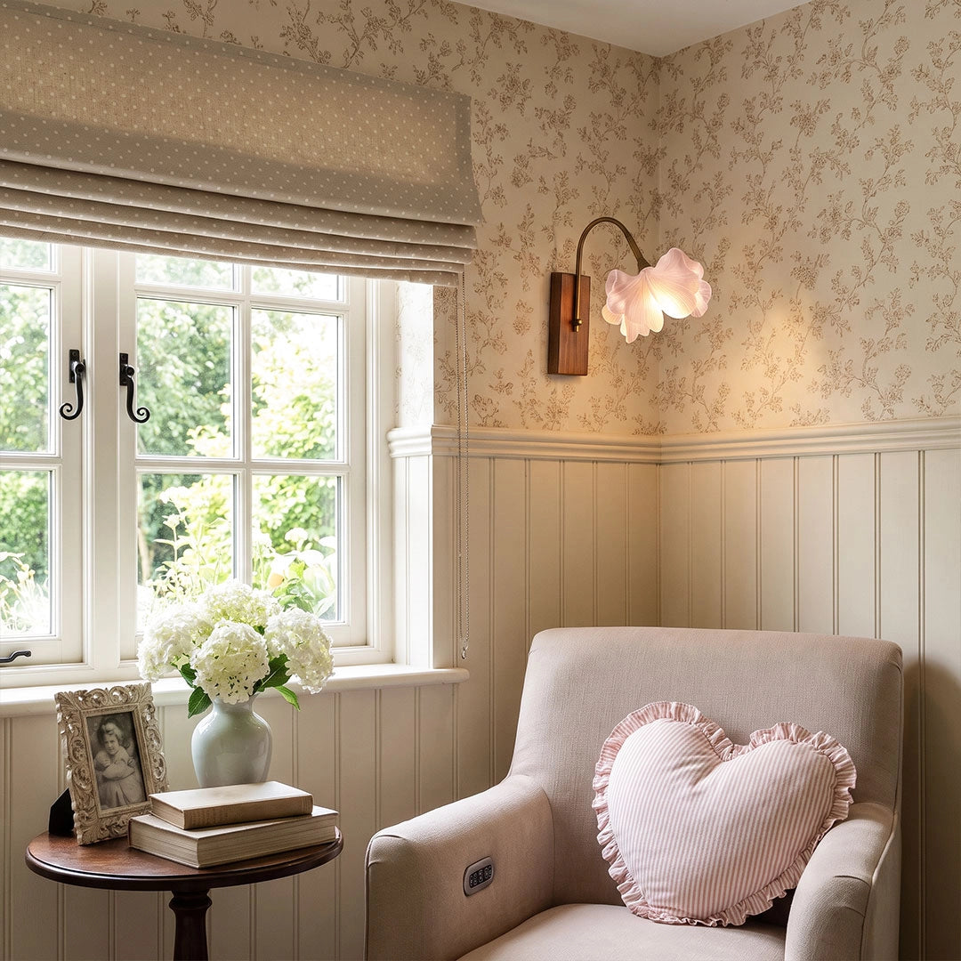 Flower wall light decorating a cozy reading nook with floral wallpaper and a cushioned chair.