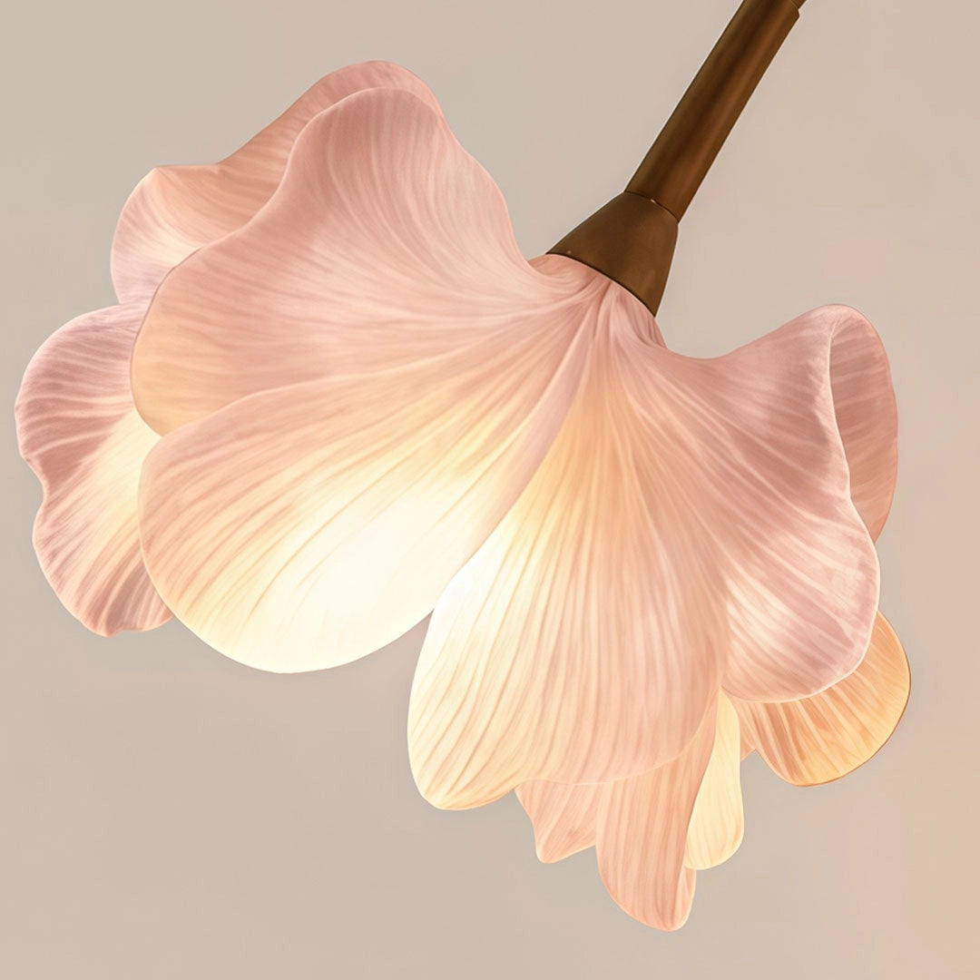 Close-up of a glowing flower wall light shade with layered pink translucent petals.