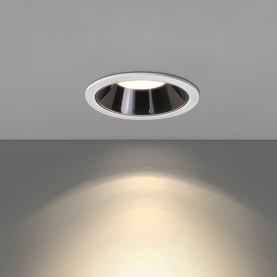 Flush-mounted adjustable downlight demonstrating wall washing effect with focused warm beam