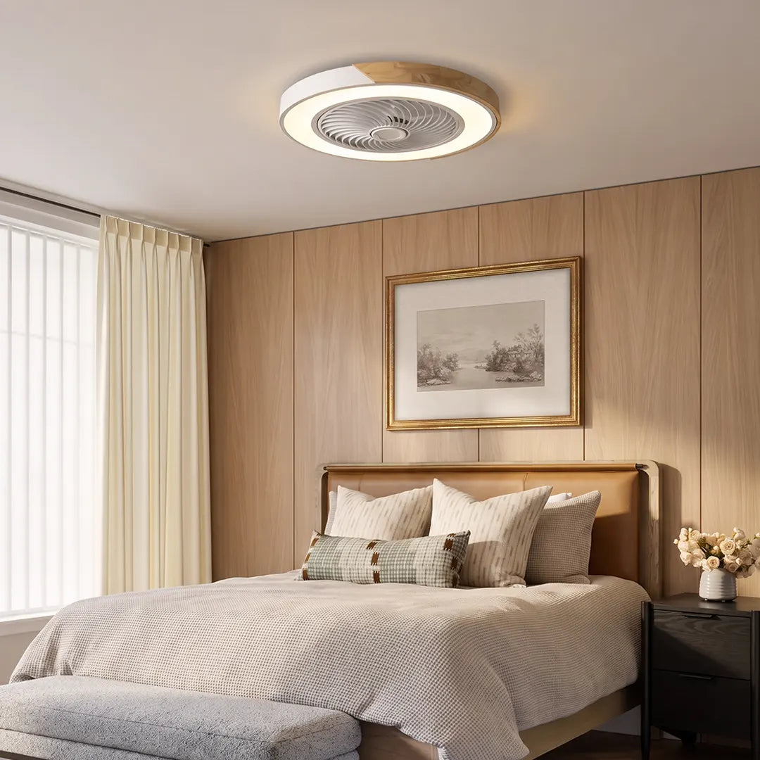 Flush ceiling fan with light and remote installed above a neutral bedroom, featuring a low-profile circular design with integrated lighting.