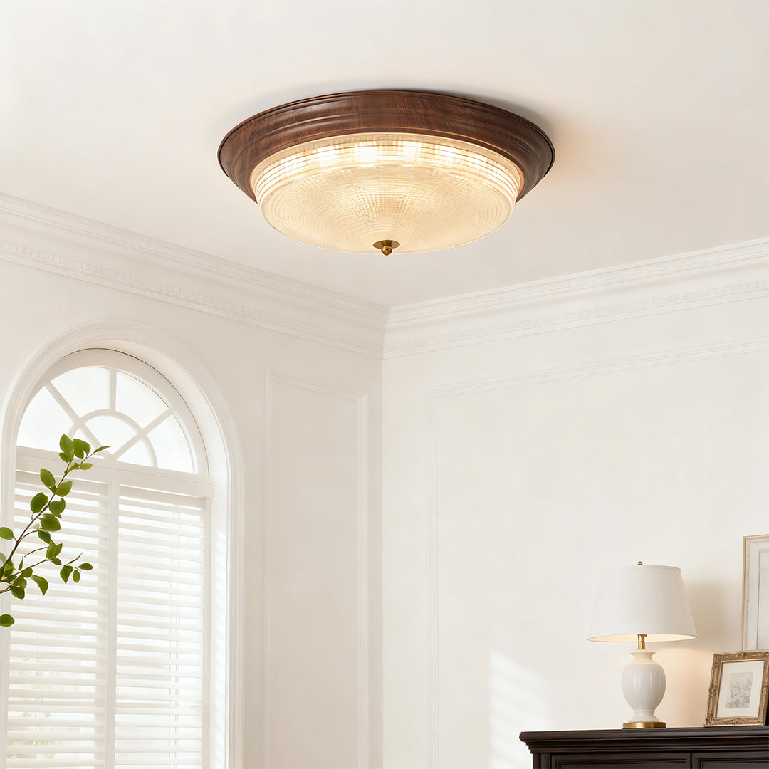 Flush mount dome light mounted in bright bedroom with arched window and neutral palette