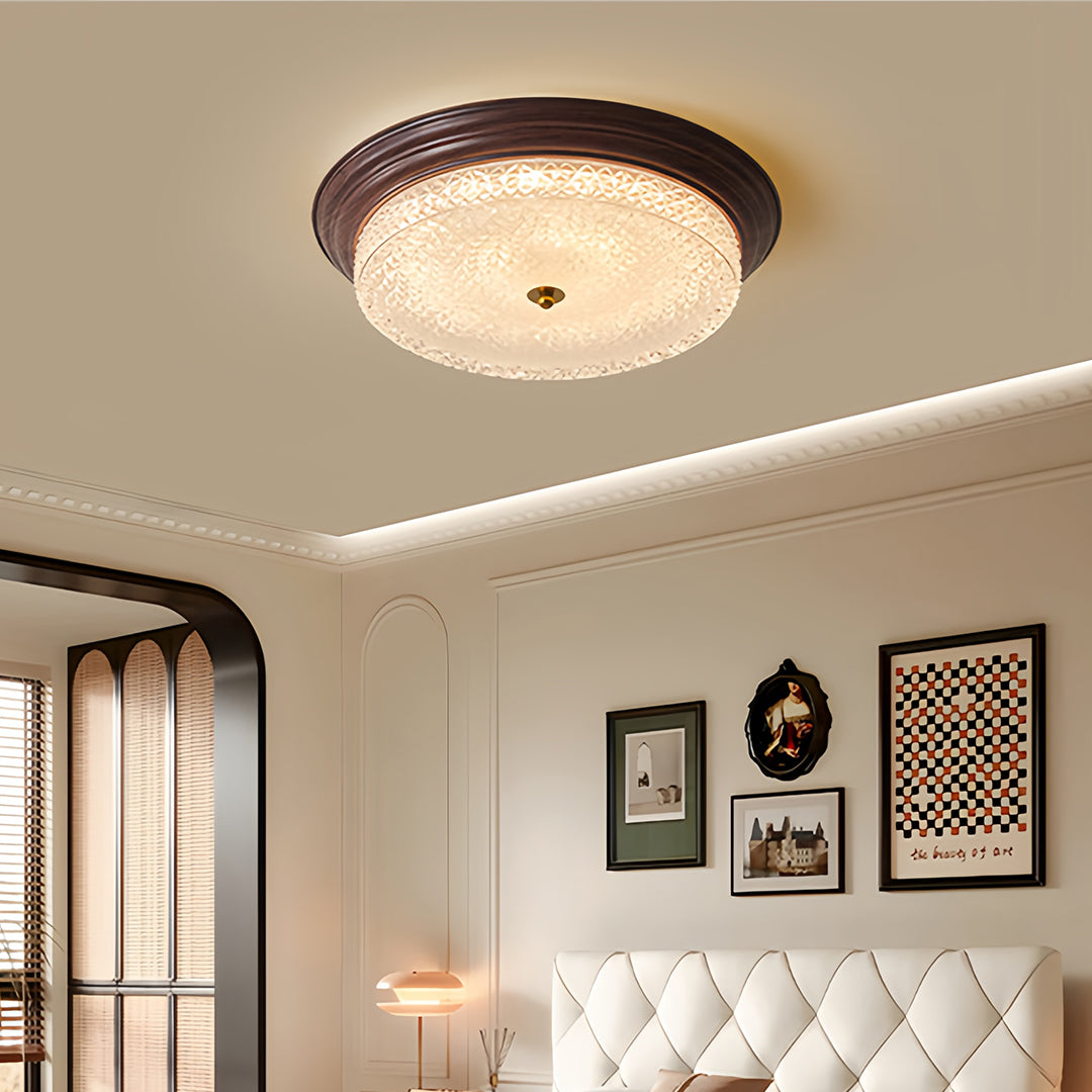 Close-up detail of flush mount dome light highlighting bronze frame and glass texture