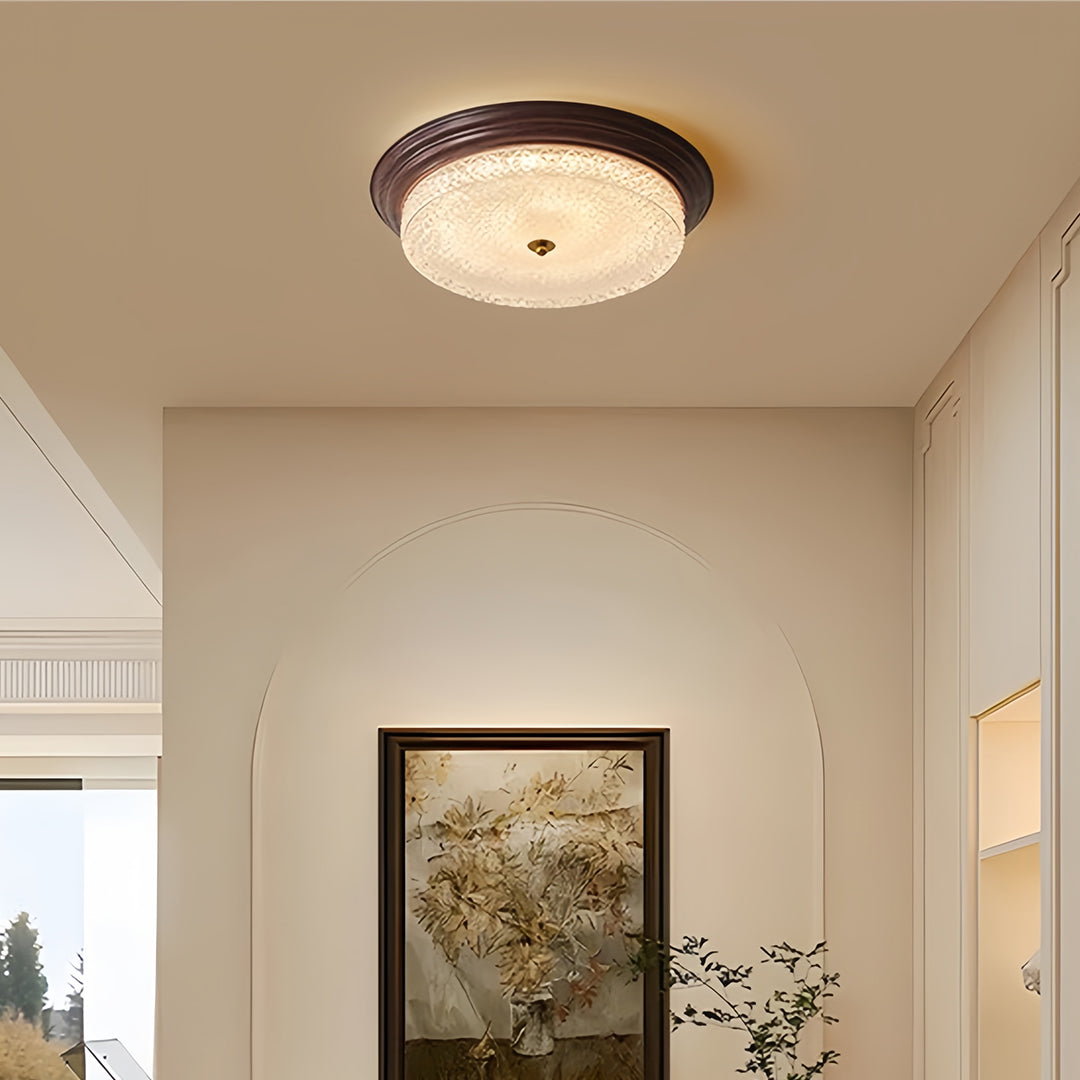 Flush mount dome light installed in contemporary hallway with white walls and artwork