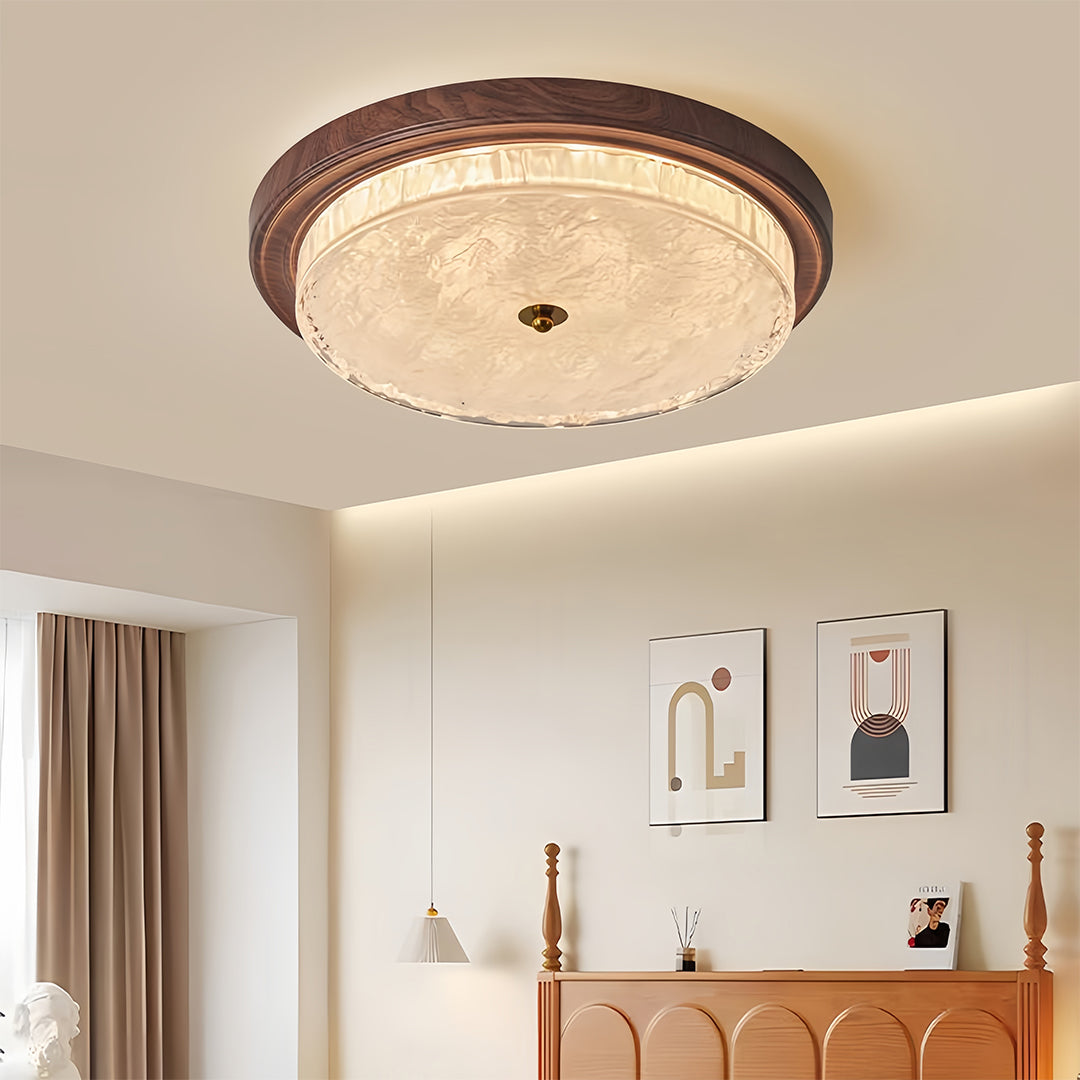 Flush mount dome light creating soft ambient glow in minimalist room with wooden furniture