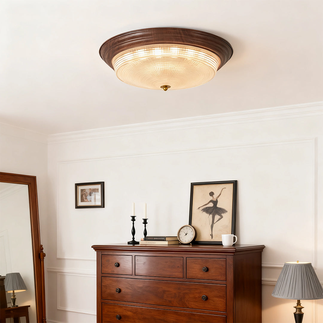 Flush mount dome light mounted in bright bedroom with arched window and neutral palette