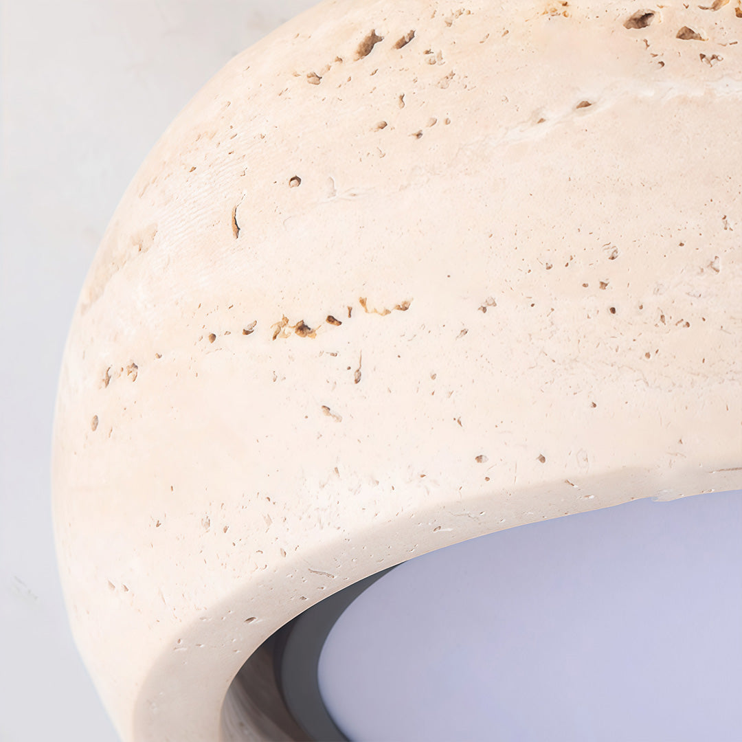Close-up of flush mount entry light highlighting the natural stone surface and rounded profile.