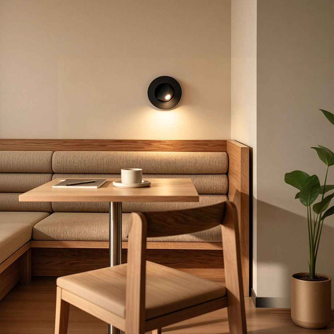 Contemporary flush mount wall light illuminating cozy cafe seating area with soft warm lighting effect.
