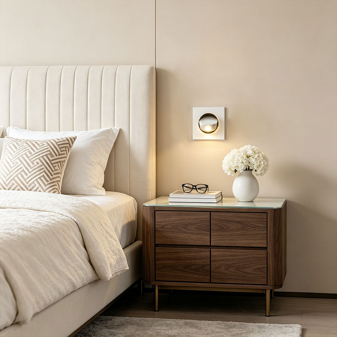 Stylish flush mount wall light installed above bedside table with modern white square frame design.