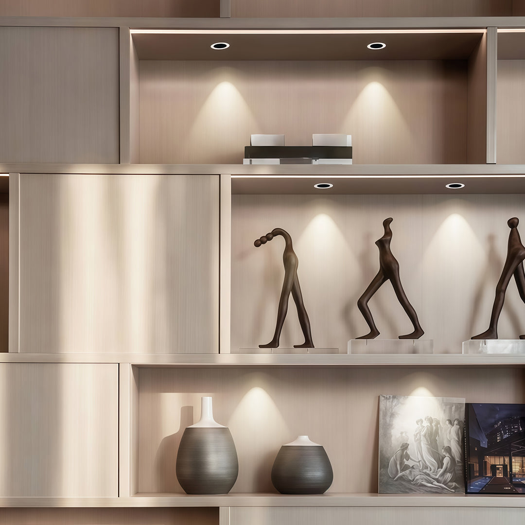 Focused indoor spotlights accenting decorative shelf display with glass shade chandelier inspired directional beam control.