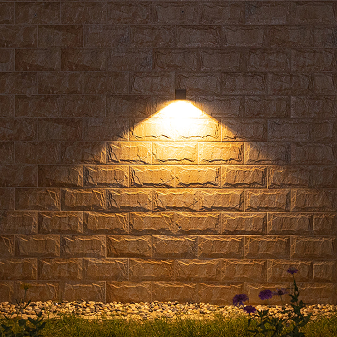 Focused warm illumination from a compact cubic Outdoor Wall Light Waterproof fixture on a rustic brick wall.