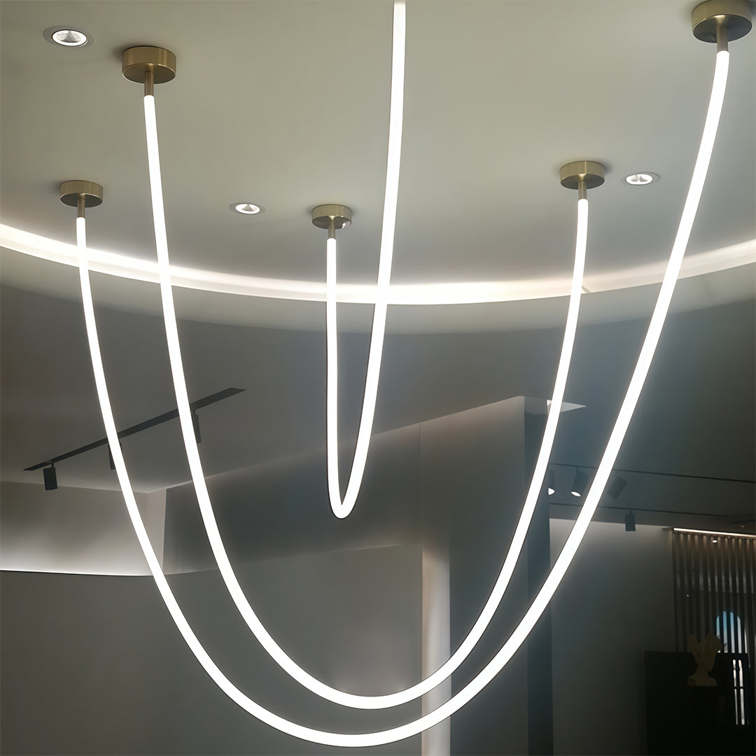 Four neon pendant lights creating rhythmic pattern against dark wall in modern space.