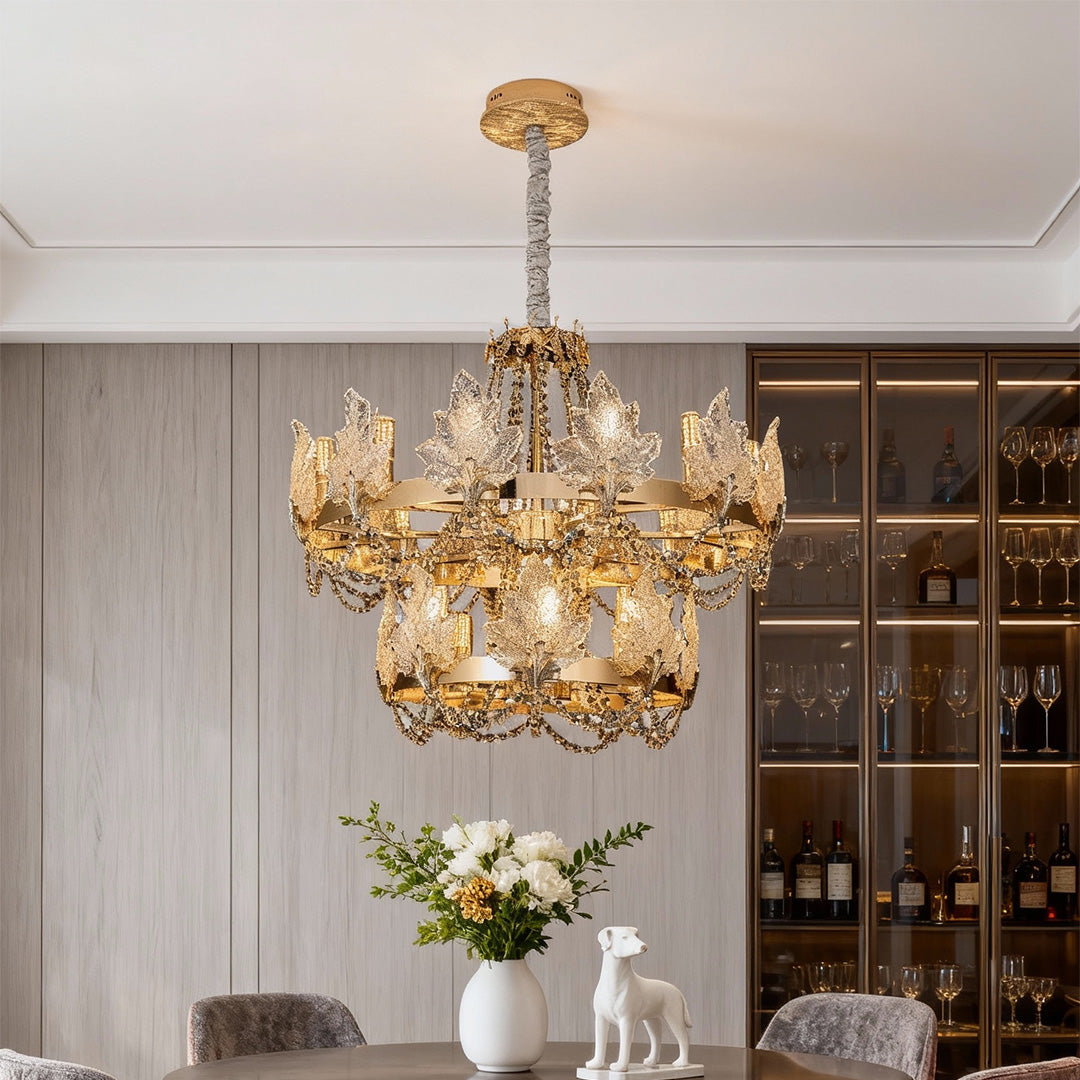 French chandelier with crystal leaf details and golden finish on black background.