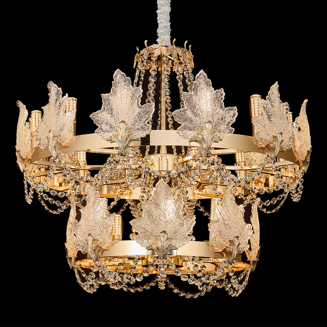 French chandelier with crystal leaf details and golden finish on black background.