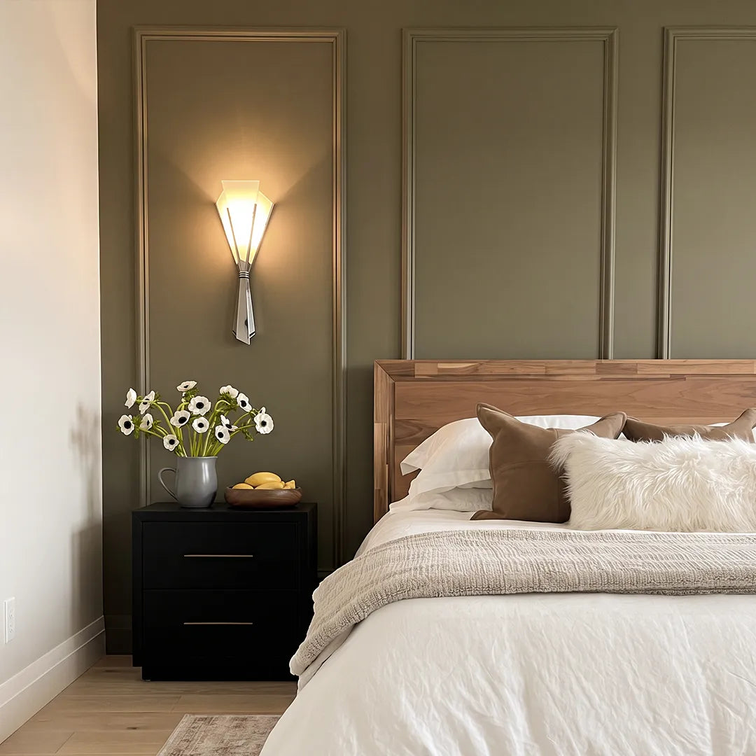 French wall sconces placed above a nightstand in a calm bedroom with paneled walls.