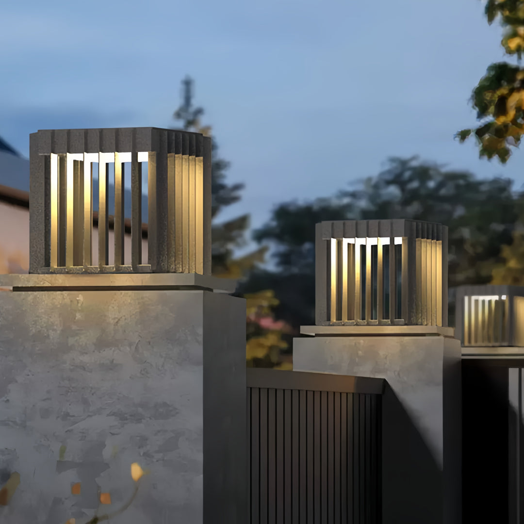 Warm glowing front pillar lights installed on modern concrete pillars along an exterior walkway.