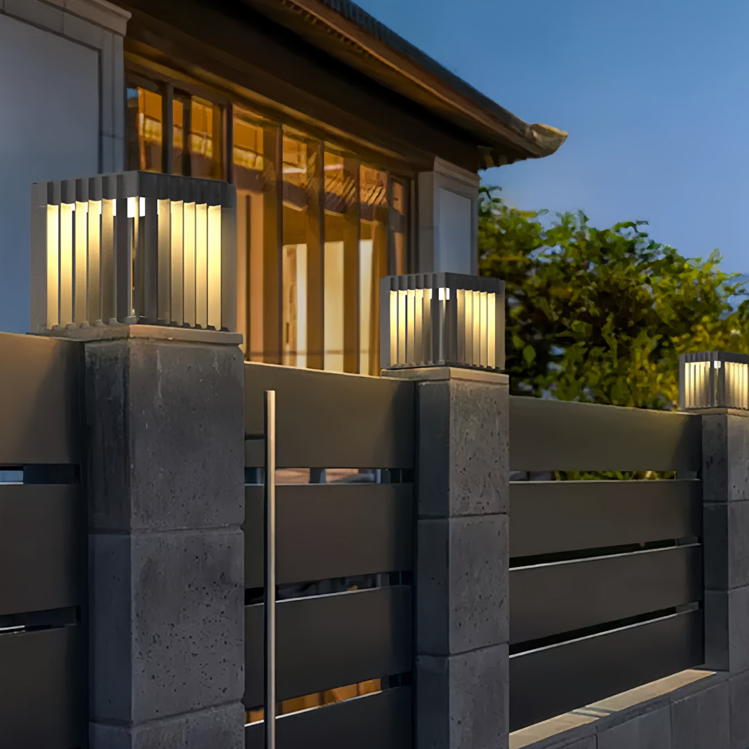 Front pillar lights mounted on contemporary exterior pillars, creating warm outdoor pathway lighting.
