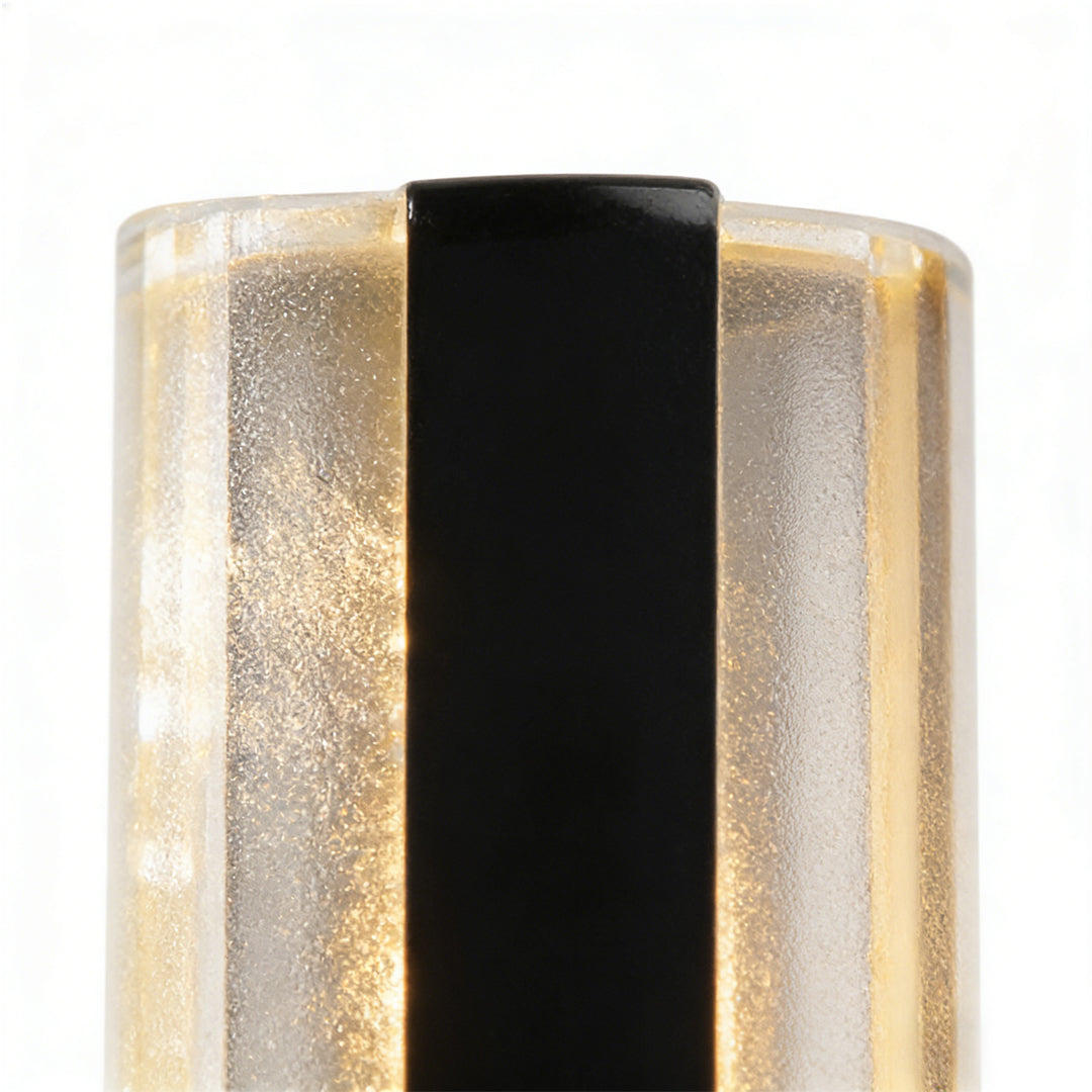 Modern linear wall sconce featuring frosted glass panels with vertical black accent, emitting warm and diffused light.