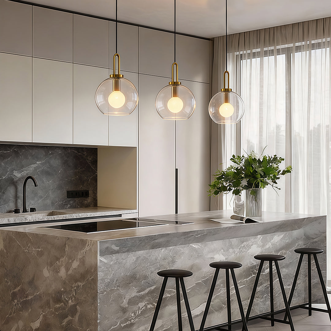 Frosted glass mini pendant lights illuminating a modern kitchen island with warm, diffused glow.
