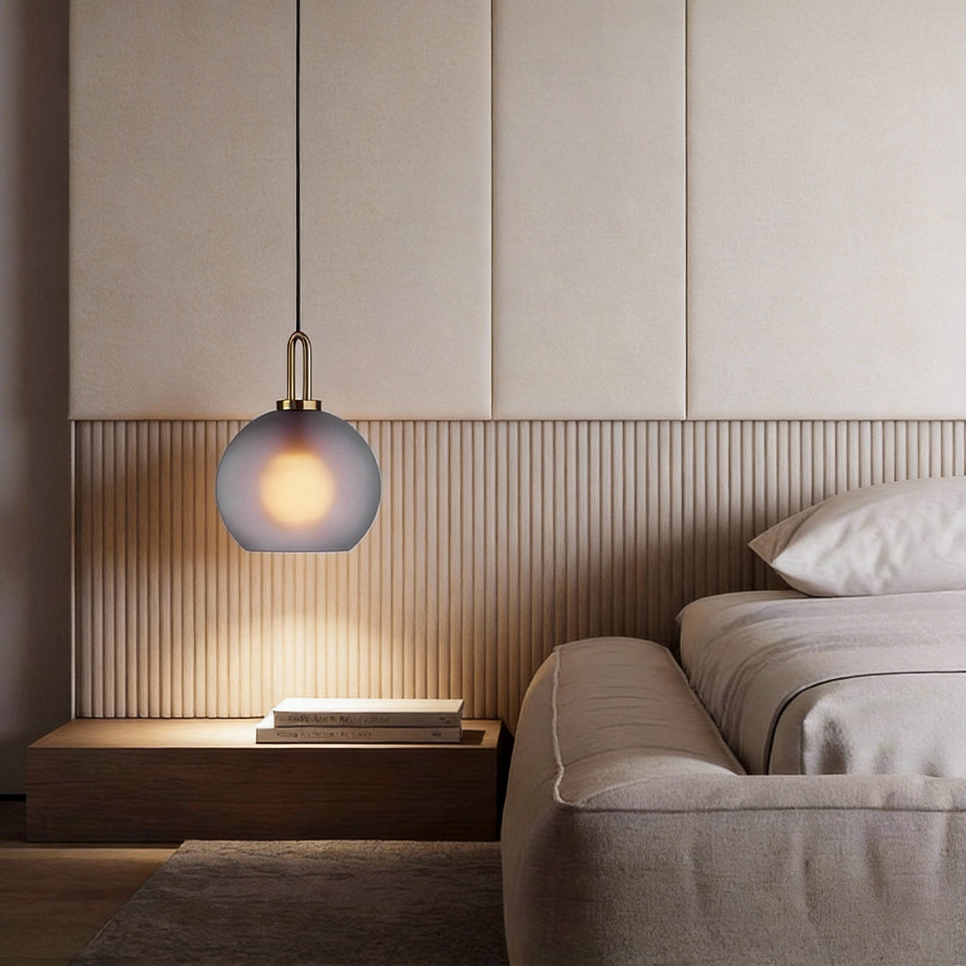 Frosted glass mini pendant lights providing soft light beside a contemporary bed.