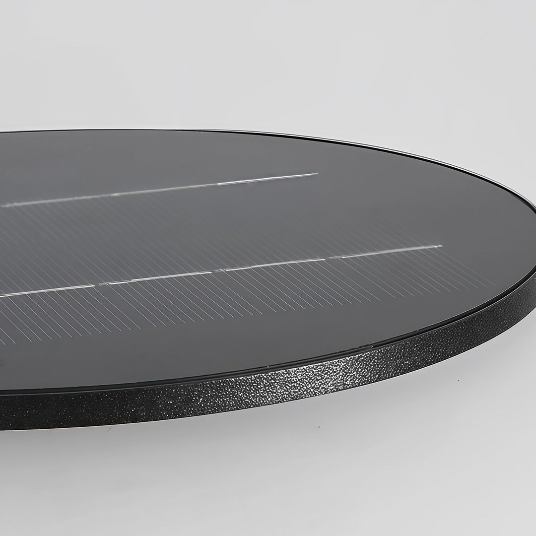 Outdoor standing light with frosted glass shade and black frame on stone patio.