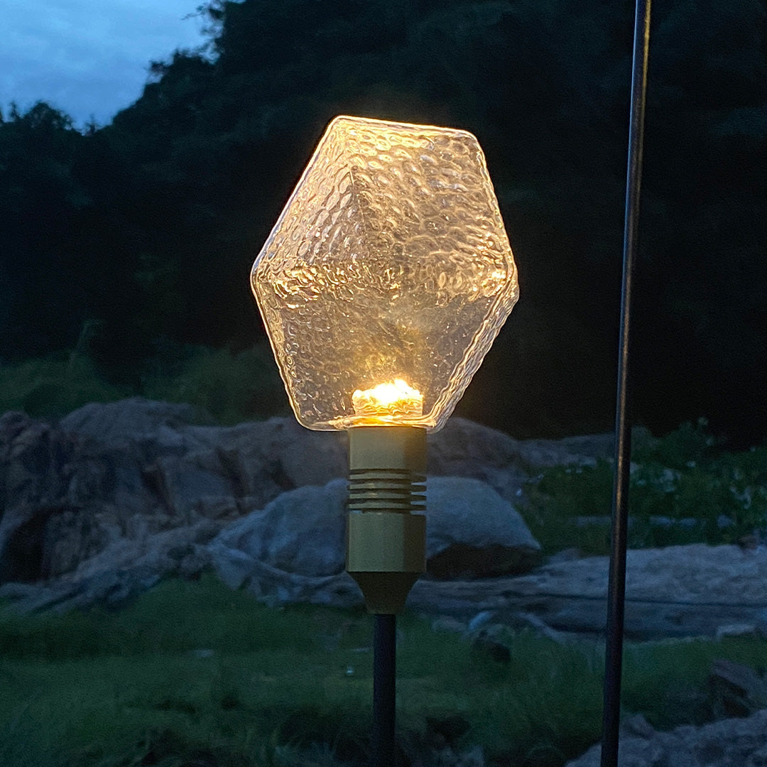 Clear frosted sphere stake lamp enhancing garden borders with soft landscape lighting pathway glow.