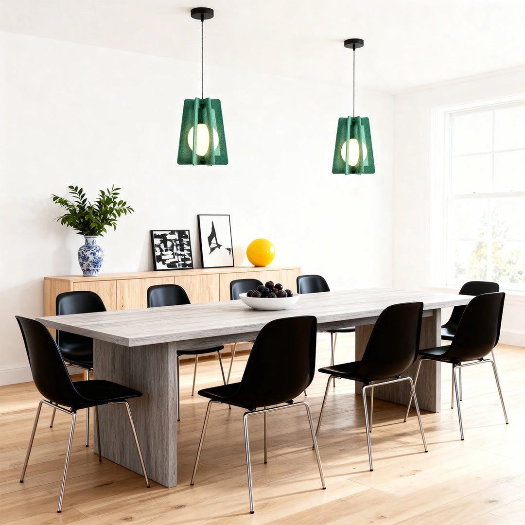 Fun pendant lights made of modern green felt with a ribbed pattern, illuminating a stylish dining space with black chairs. 
