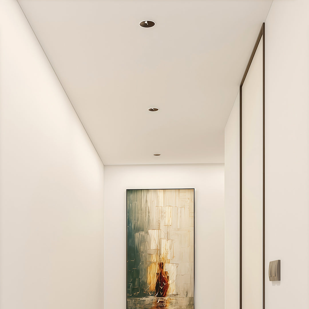 Modern adjustable spotlights with glass shade chandelier design installed in gallery hallway for artwork illumination.