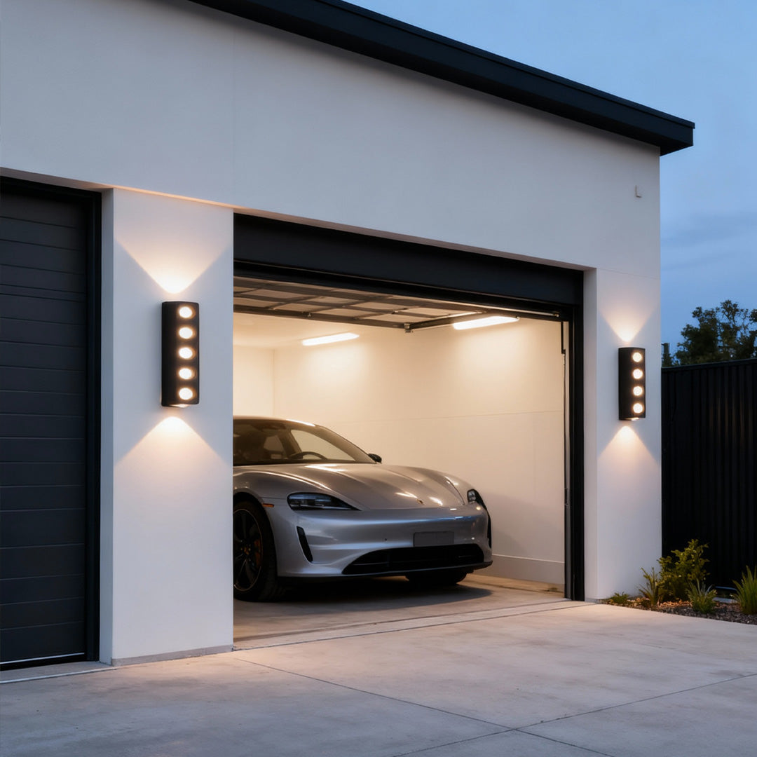 Garage exterior featuring modern unique outdoor wall lighting installed beside the entrance for warm accent illumination.