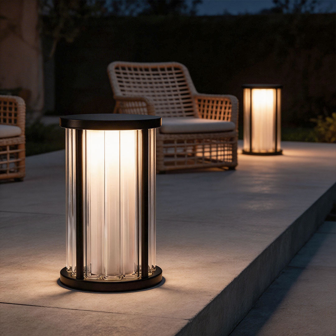 Garden bollard lighting with a modern design, illuminating a patio seating area.
