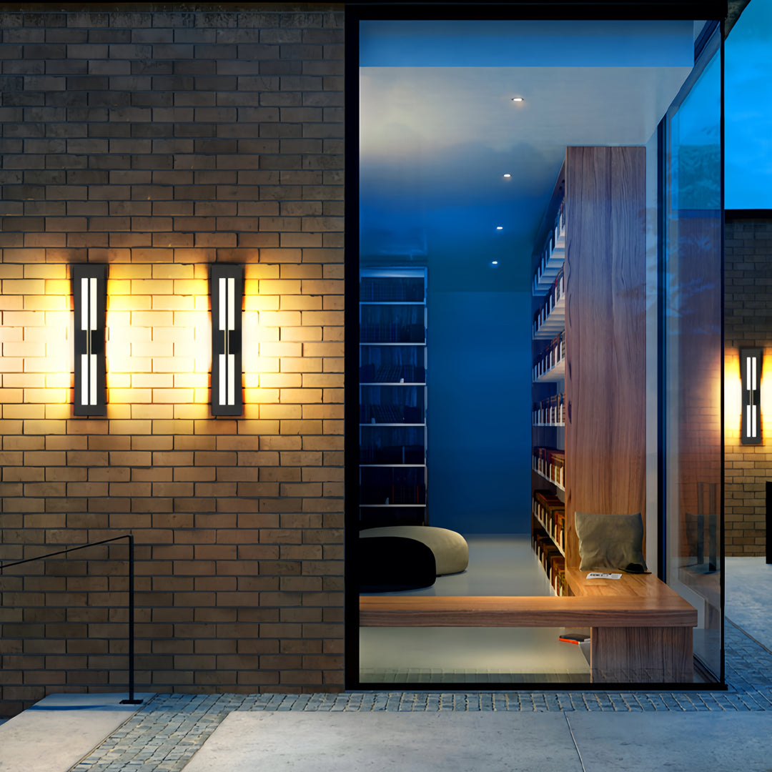 Modern garden bollard lighting mounted on an exterior wall, illuminating a contemporary outdoor pathway at dusk.