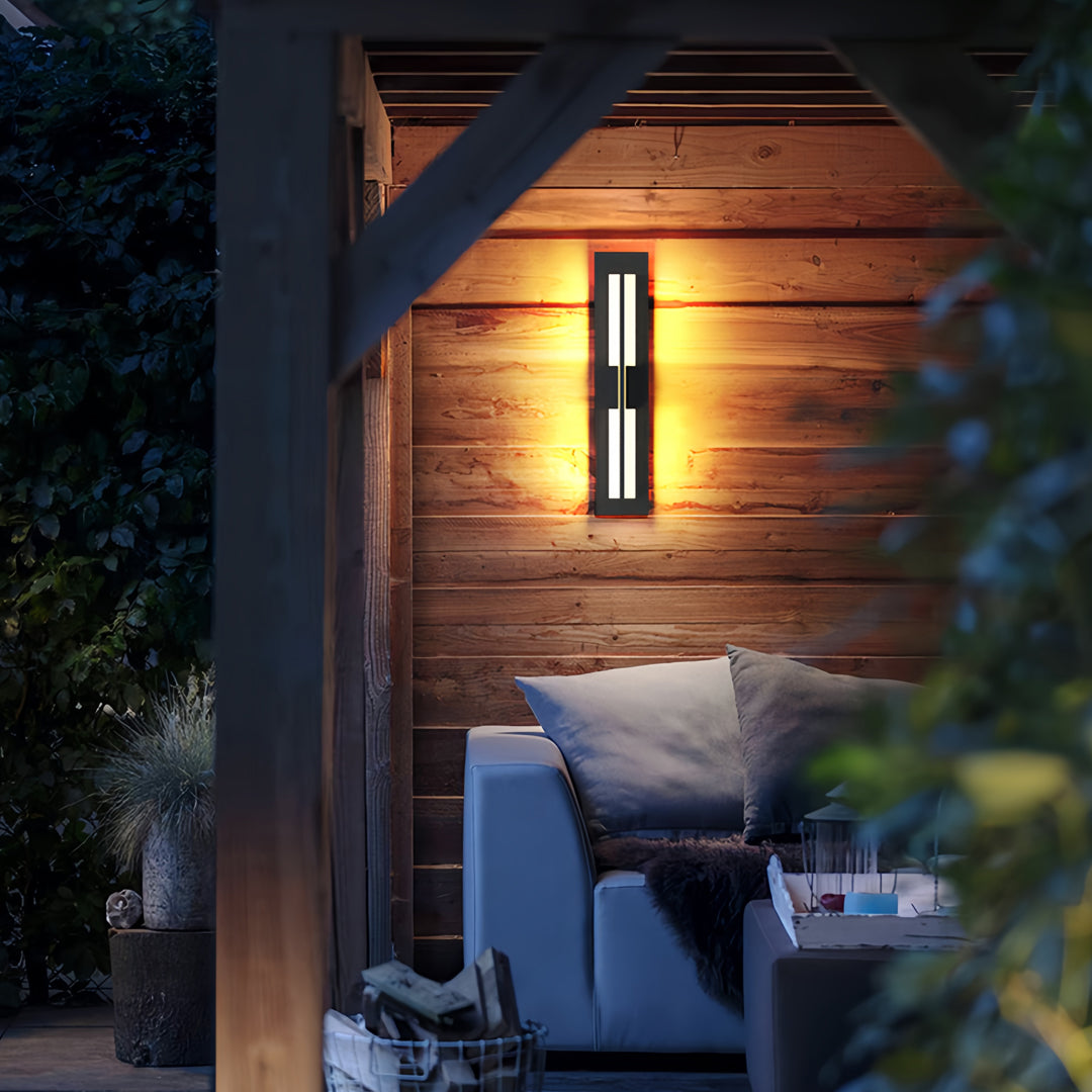 Warm garden bollard lighting installed beside wooden exterior walls, enhancing the cozy outdoor seating area.