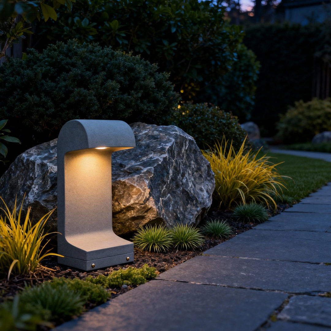 Modern landscape led lighting brightening a garden corner with a compact curved-top bollard placed beside decorative stones.