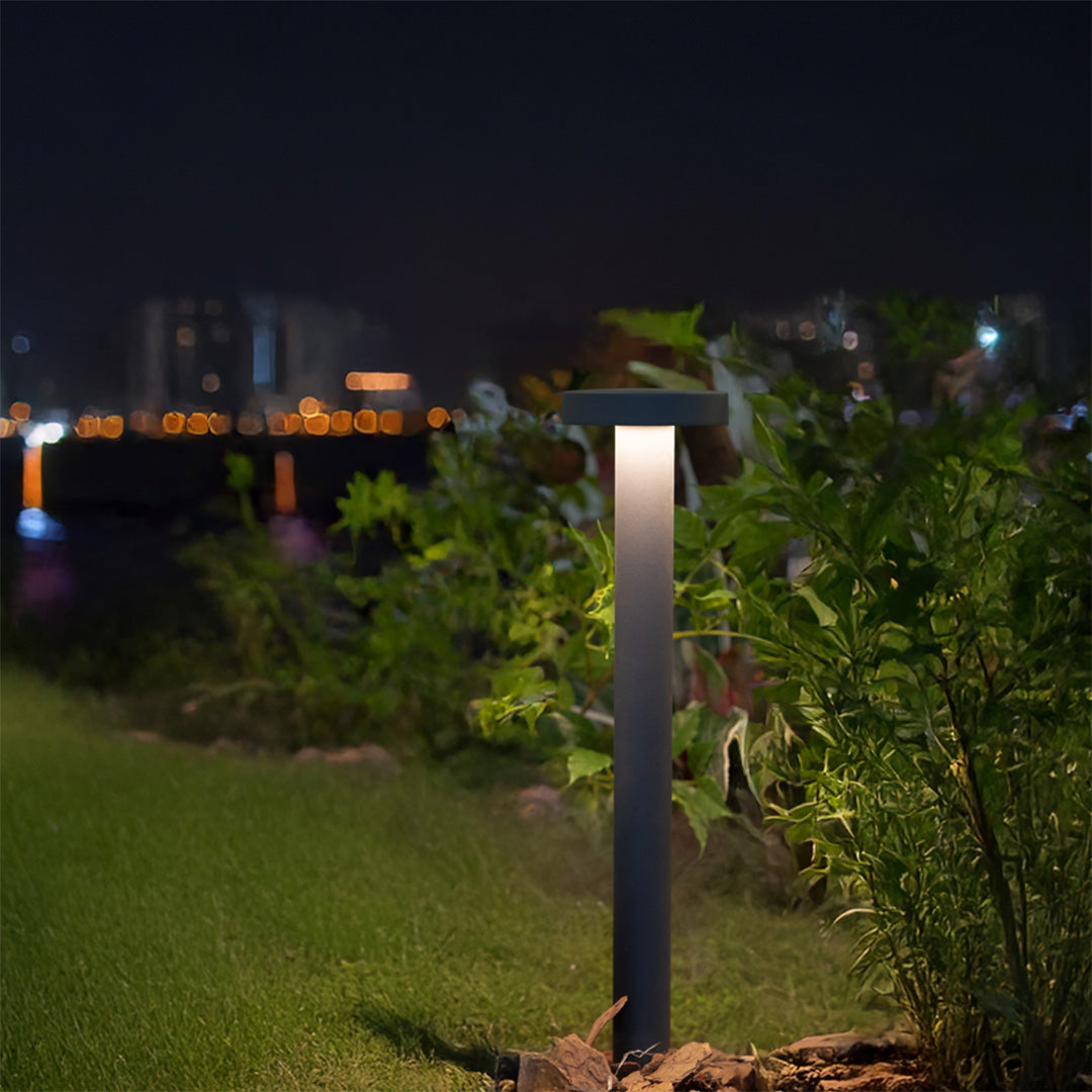 LED path light creating warm evening glow in residential garden setting with natural landscaping