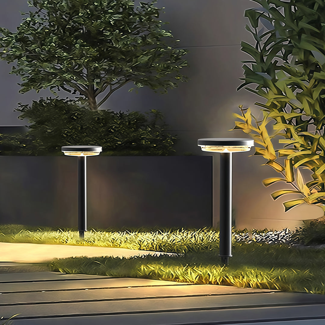 Path light solar fixtures lighting up garden pathway during evening hours.