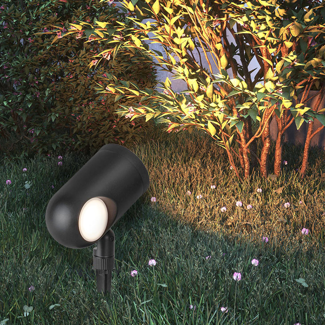 Outdoor waterproof spotlight illuminating garden hedges with warm focused light.