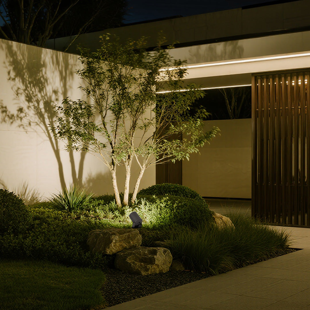 Garden LED landscape spotlight providing accent lighting for stone wall and landscaped area