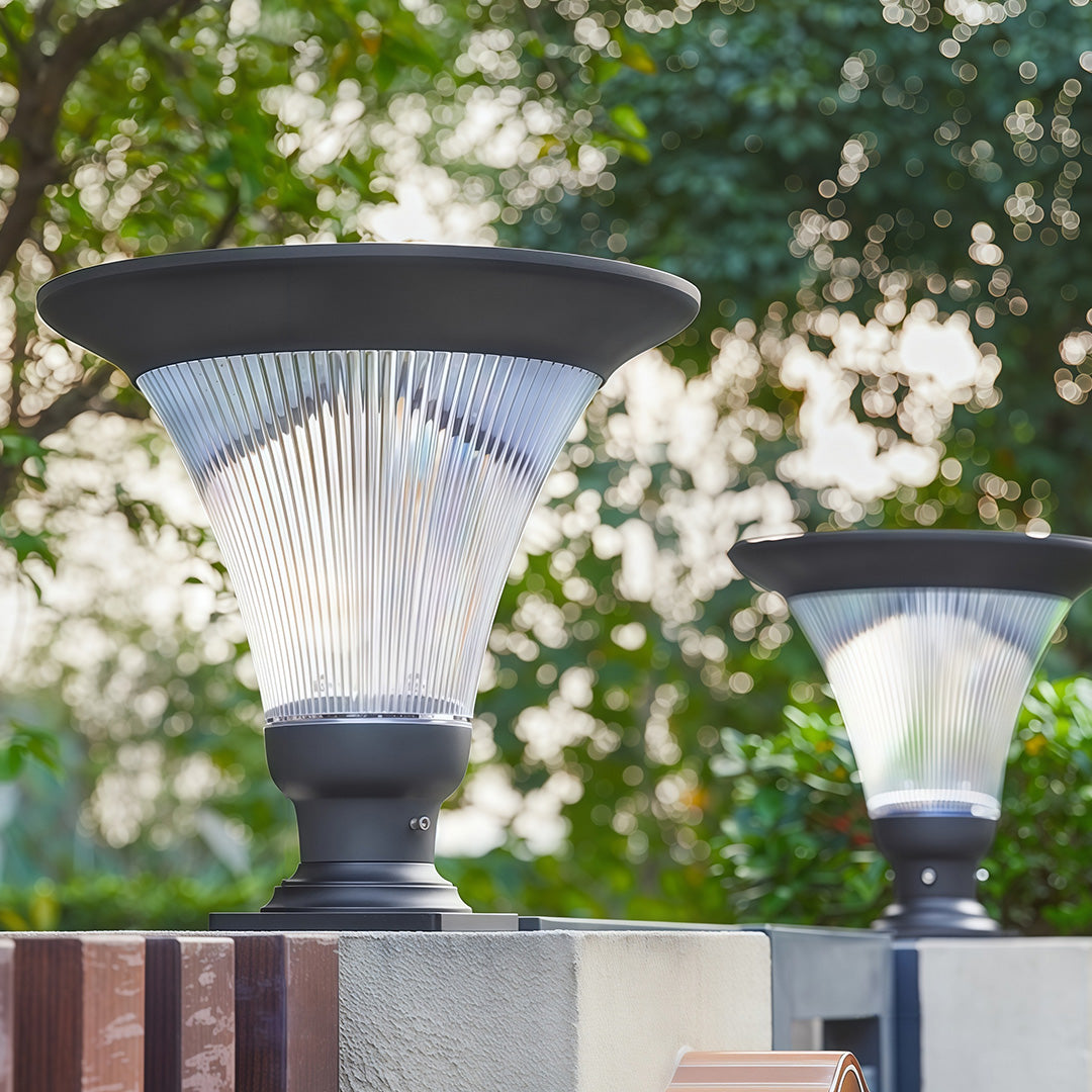 Garden light pillar with soft glow lighting up a beautiful landscape at dusk.