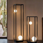 Bollard outdoor lighting along a garden path, providing a modern look with its geometric black frames and warm lights.